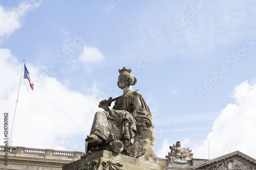 Statue representing Lille in the Place de la Concorde Paris by James Pradier in 1836 to 1838. French flag waving on top of historical building.