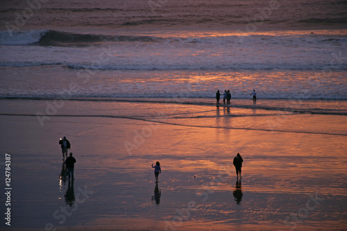 ppl on beach w ocean sunset photo