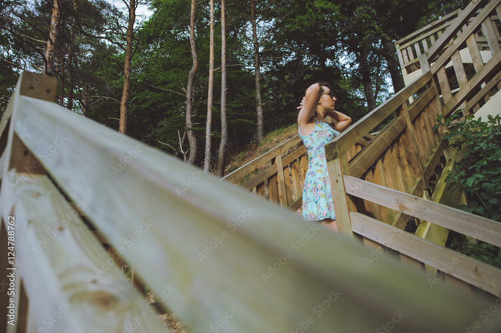 girl sitting on the wooden stairs in park and smiling