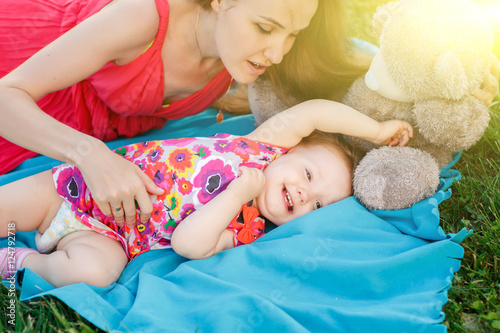 Mom and little daughter lying on blue blanket