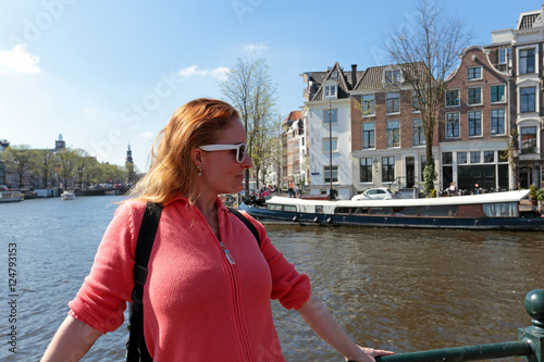 Young native dutch woman on a medieval bridge in Amsterdam Nethe photo