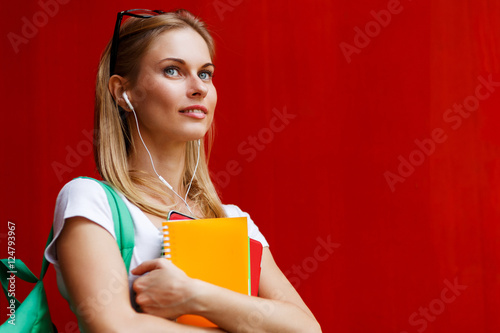 Portrait of girl with headphones at red blank walls photo