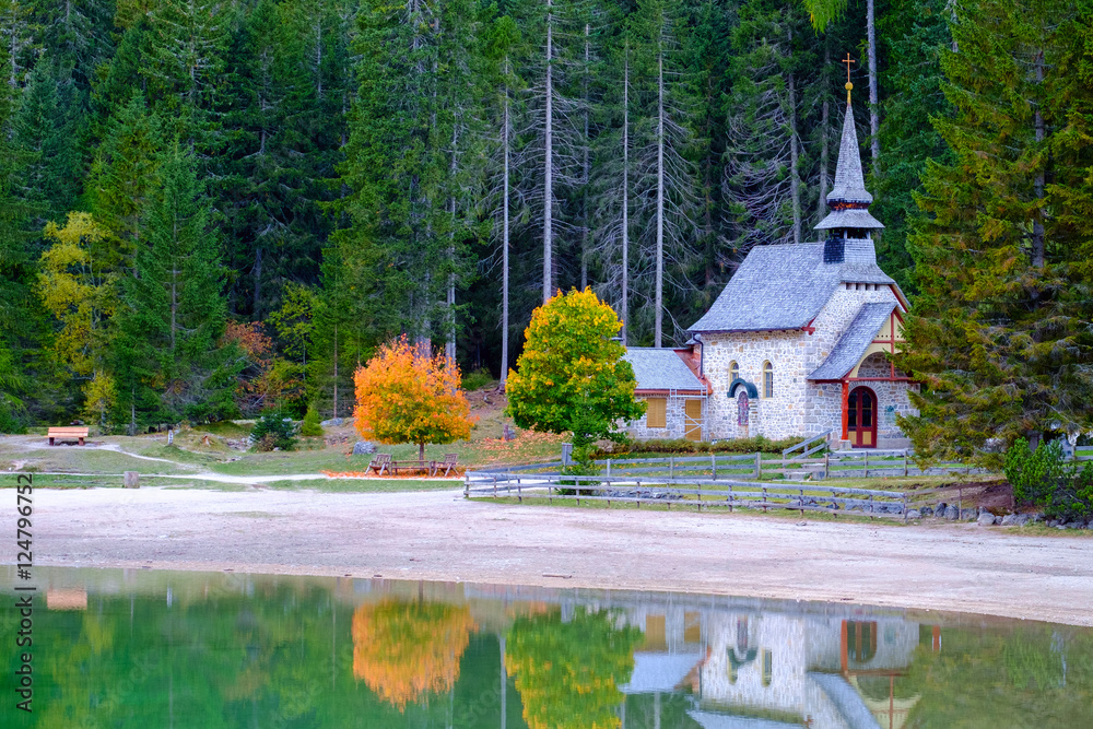 Little chapel at the Braies Lake in Dolomites mountains