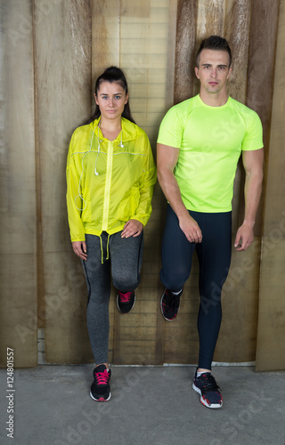 Young and beautiful athletic woman and man against rustic backgr