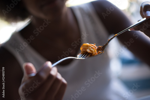 a young African American woman eating pasta