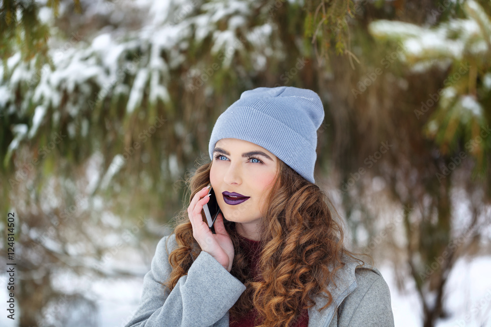 Hipster Girl talking on the phone in the winter. Hipster Girl talking on the phone in the winter.
