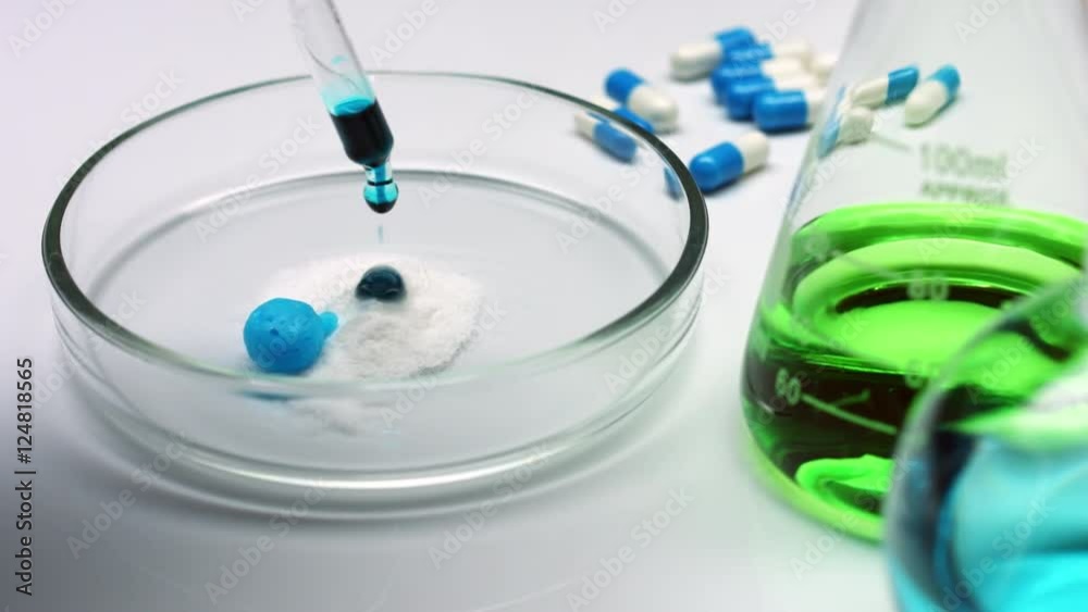 Violent reaction of cyan liquid dropped on white powder pile in petry dish