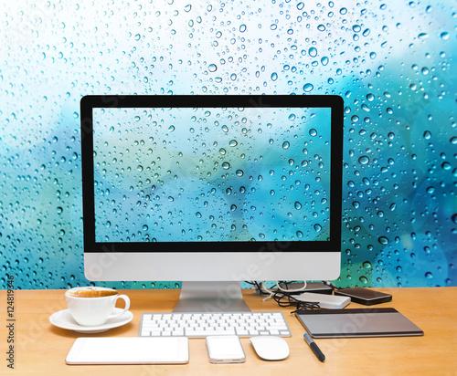 Workspace with computer desktop on the wood table with a glass s photo