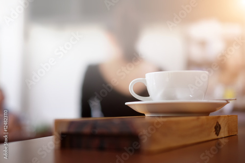 closeup white cup of coffee on wooden plate