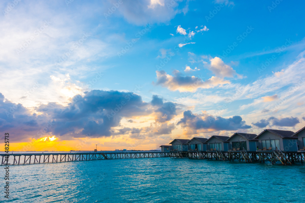 Beautiful sunrise with  water villas  in tropical Maldives islan