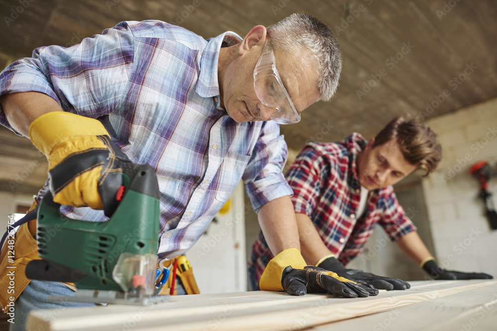 Creative carpenter works with younger one. Creative carpenter works with younger one.
