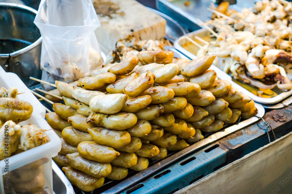 Evening street food in Bangkok, Thailand : Grilled squid on gridiron in evening street market, Squid barbecue in Thai street food market