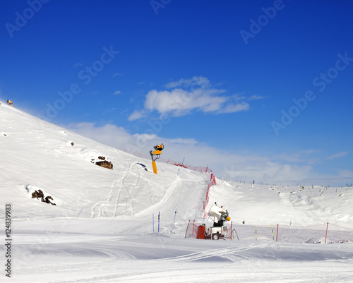 Ski slope with snowmaking at sun day photo