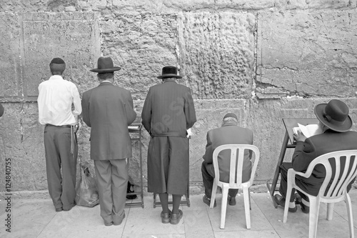 men praying at western wall 3 bw