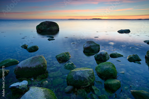 Sonnenuntergang an der Ostsee   Insel R  gen  Greifswalder Bodden  Gro  e Findlinge  Windstille  glattes Wasser 