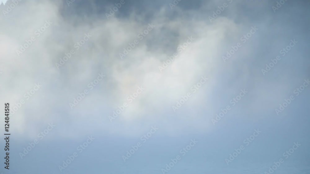 Drifting fog above mountain lake through the trees Drifting fog above mountain lake through the trees
