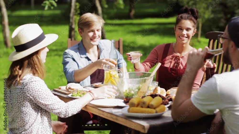 happy friends having dinner at summer garden party happy friends having dinner at summer garden party