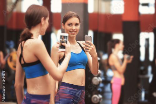 Young sportive woman taking selfie near mirror in gym © Africa Studio