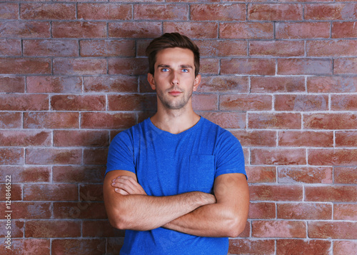 Young handsome man on brick wall background