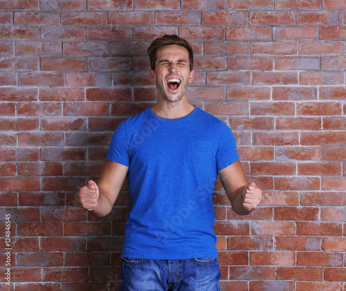 Young handsome man on brick wall background