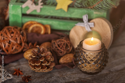 Composition of candle and natural decor on wooden background, close up view