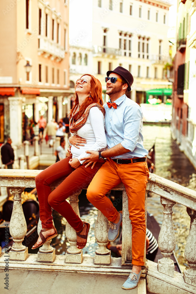 Man in orange trousers hugs from behind his woman whilre resting