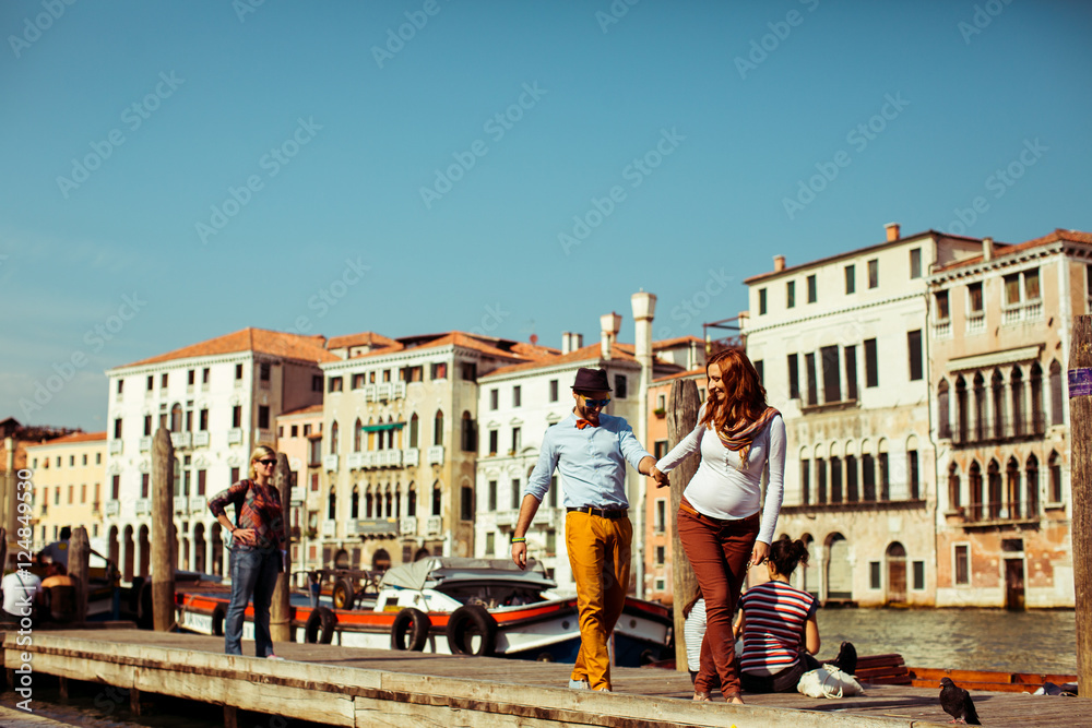 Happy couple walks along the berth in Venice