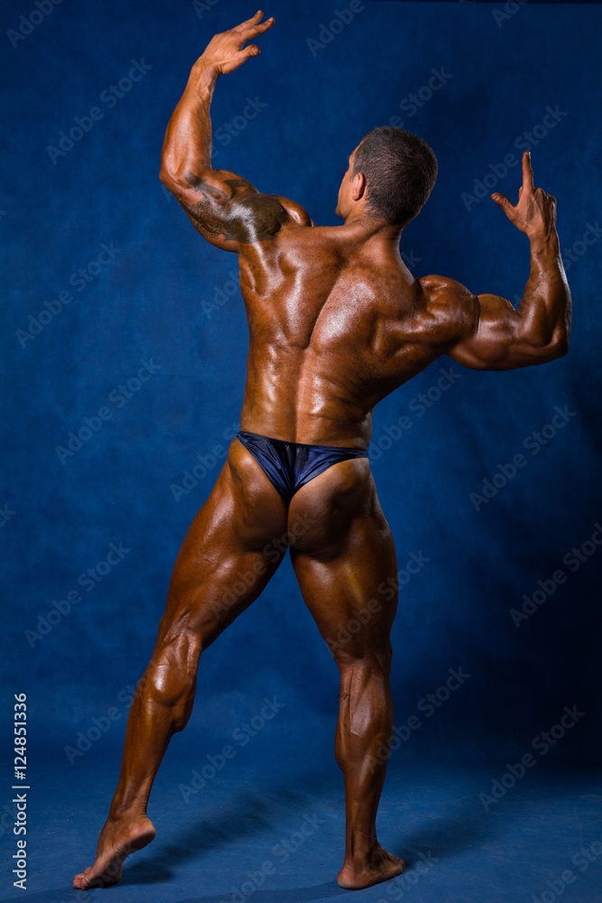 Muscular athletic man in a pose with his back Muscular athletic man in a pose with his back