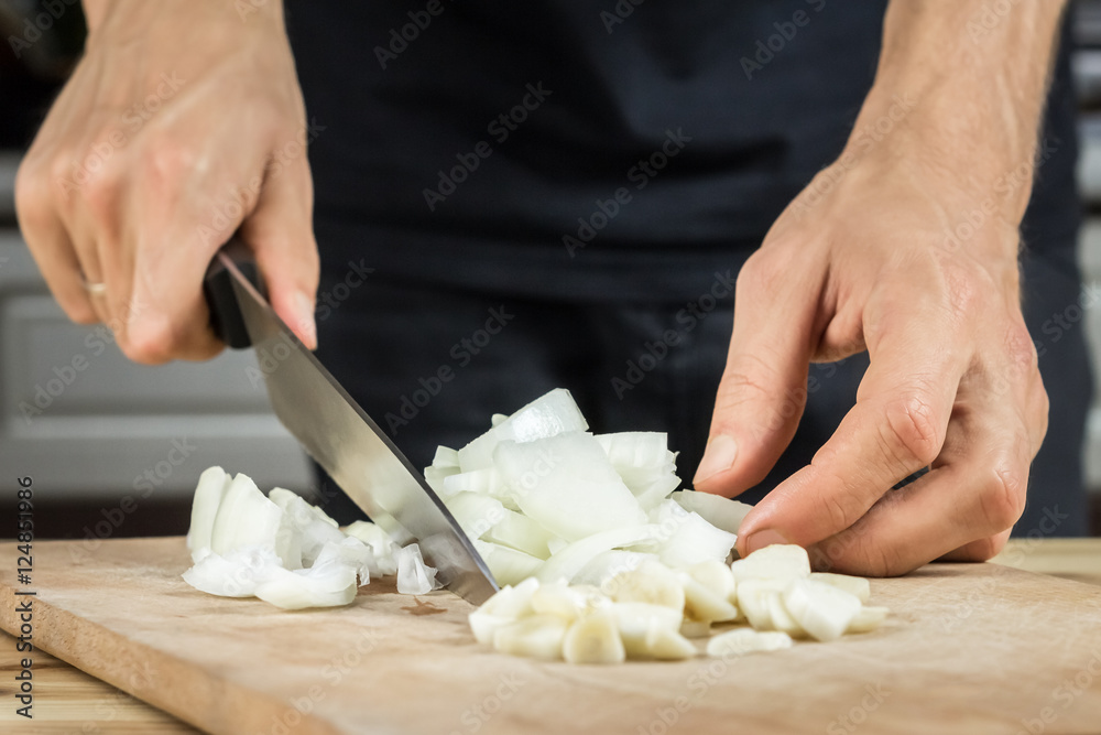 Cutting onion and garlic on wood cutting board Cutting onion and garlic on wood cutting board