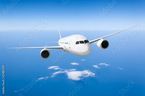 Podróż samolotem, samolot latający w błękitne niebo nad chmurami