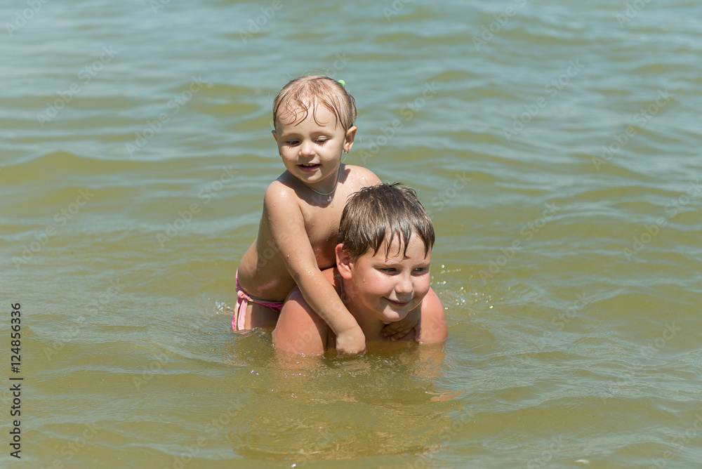 Boy and girl, brother and sister playing in the water, summer vacation, carefree childhood, upbringing and development of children. Boy and girl, brother and sister playing in the water, summer vacation, carefree childhood, upbringing and development of children.