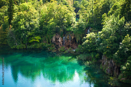 Waterfall and lake with transparent emerald water