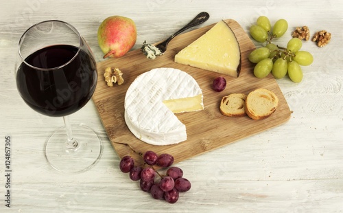 Red wine and selection of cheeses with grapes