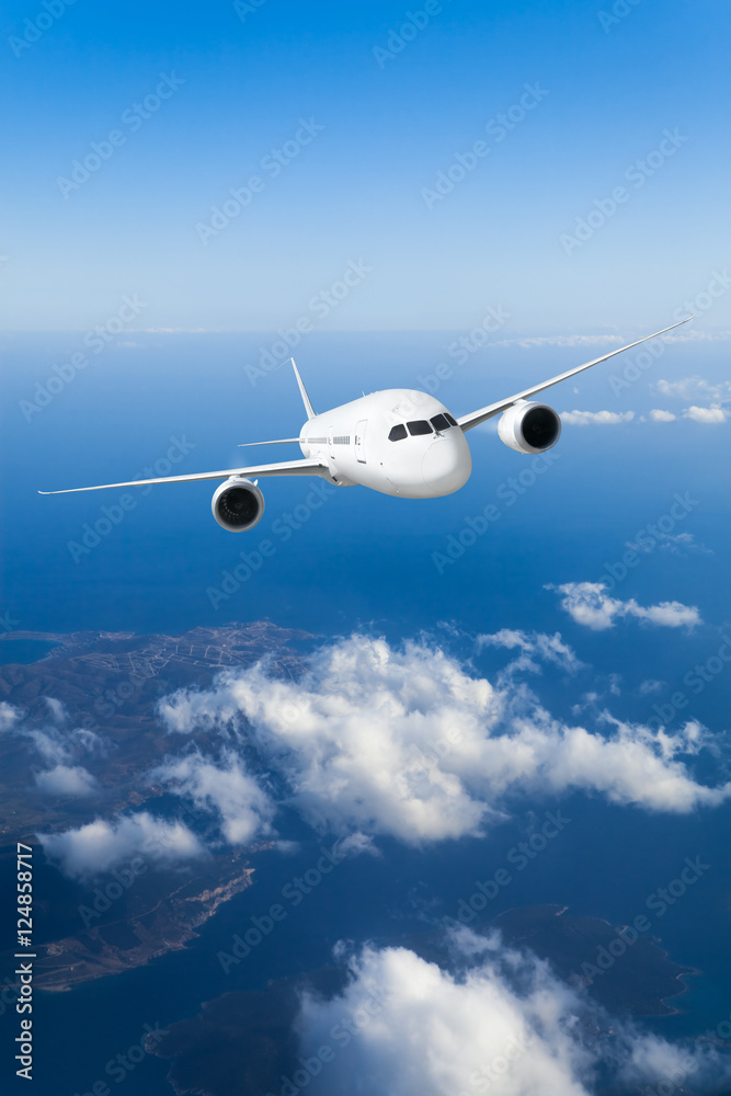Podróż samolotem, samolot lecący w błękitnym niebie wysoko nad ziemią - obrazy, fototapety, plakaty 