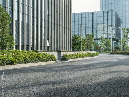 empty asphalt road by modern office building. © kalafoto