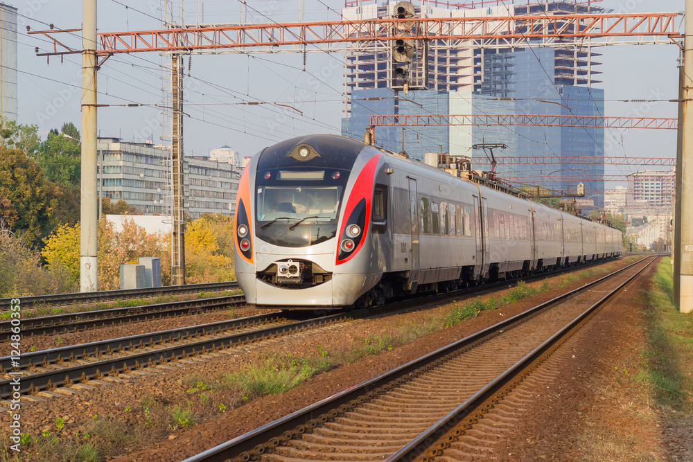 Passenger inter-city train on the background of urban developmen