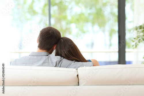 Couple sitting on a couch looking through window