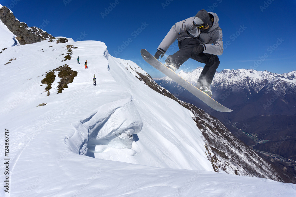 Snowboarder jumping on mountains. Extreme snowboard freeride sport.