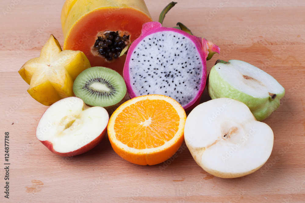 Mix half cut fruit on wooden table Mix half cut fruit on wooden table