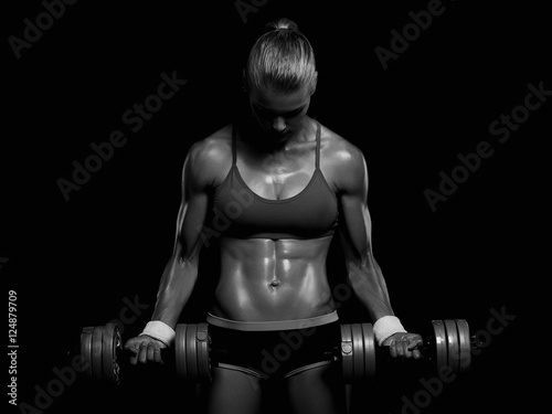 athletic bodybuilder woman with dumbbells.beautiful girl with muscles.gym