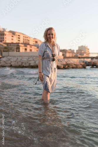 Fototapeta Naklejka Na Ścianę i Meble -  Happy carefree woman dancing at sunset on the beach. Happy free