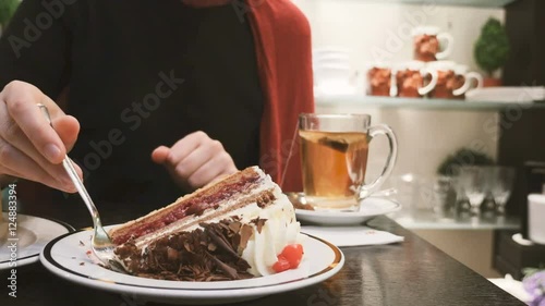 Woman eating Black Forest gateau (British English) and Black Forest cake (American English and Australian English) are the English names for the German dessert Schwartzwalder Kirschtorte