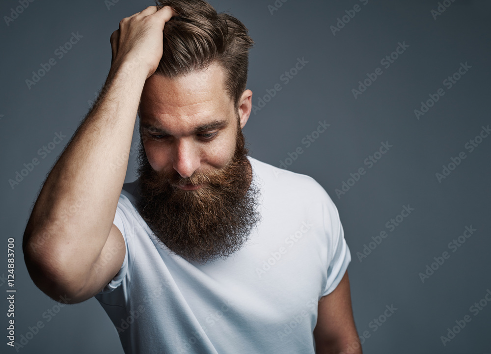 Thinking bearded man holding hair and laughing Thinking bearded man holding hair and laughing