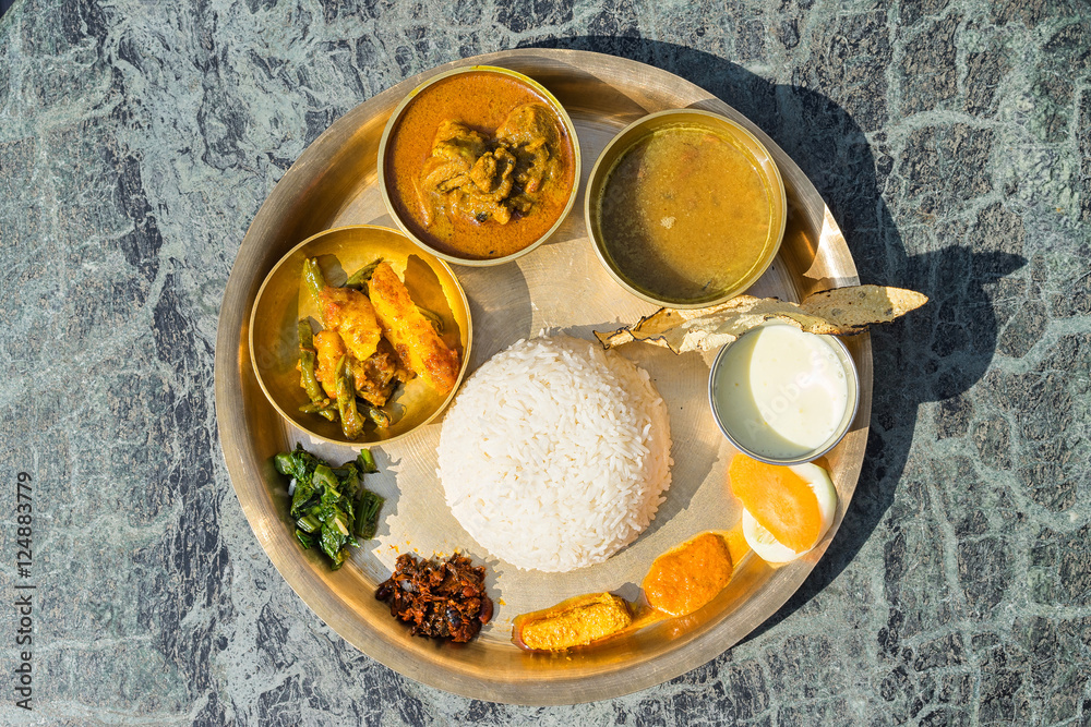 Traditional Nepalese food - thali (dal bhat) in a restaurant. Overhead  view. Selective focus. foto de Stock | Adobe Stock
