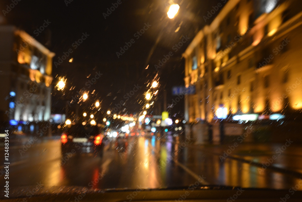 Drops of rain on the window of the car, the lights of the night