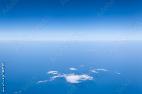 Piękny widok z samolotu na horyzont - błękitne niebo nad chmurami i ocean