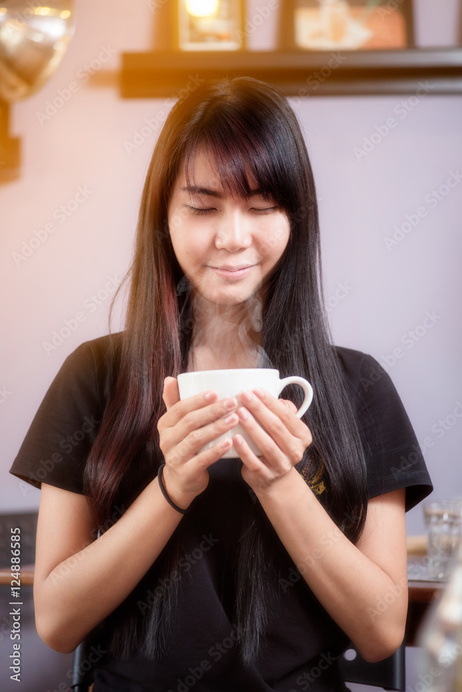 Traveler girl living happily inside a coffee shop. She inhaled the aroma of coffee in the cup. Traveler girl living happily inside a coffee shop. She inhaled the aroma of coffee in the cup.