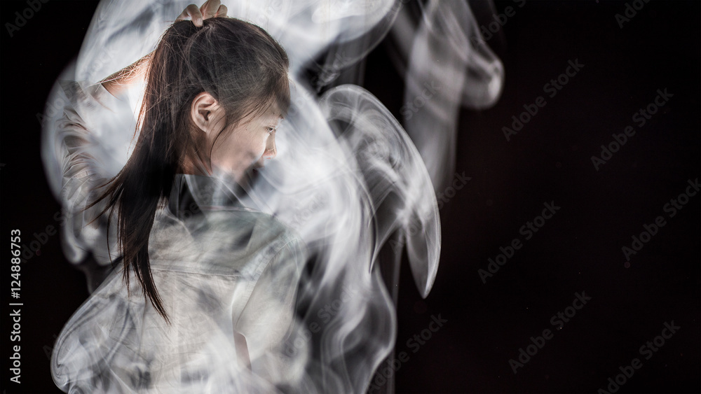 a girl in smoke on black background.