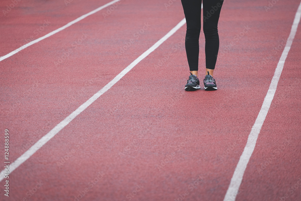 Female legs in sport sneakers on the track Female legs in sport sneakers on the track