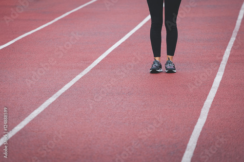 Female legs in sport sneakers on the track